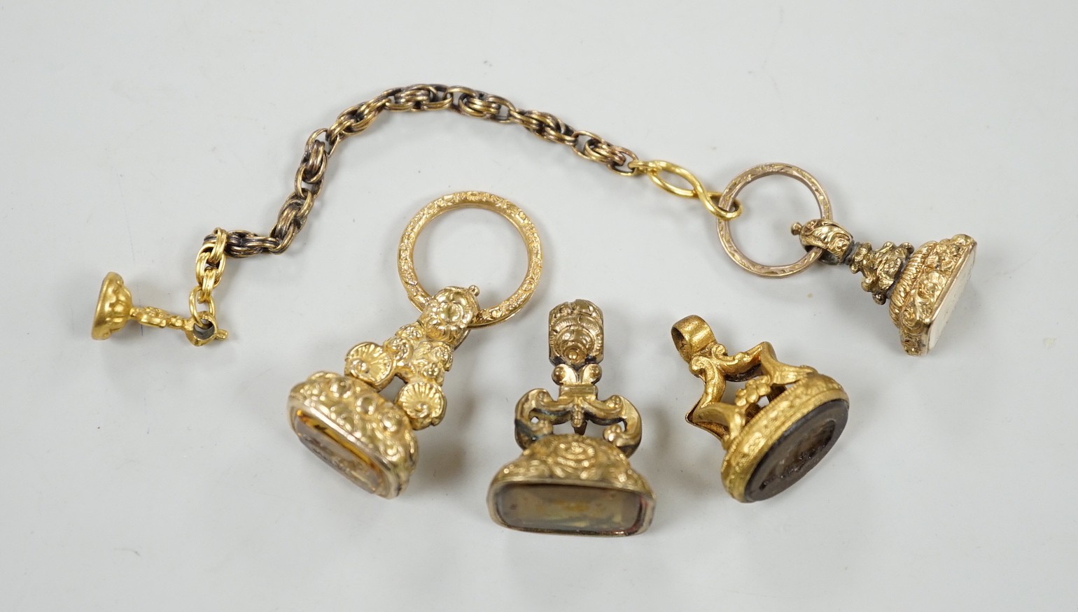 Four assorted 19th century gold plated fob seals, set with citrine, glass or carnelian, largest 30mm.